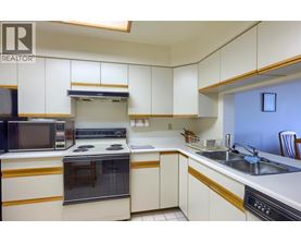 A kitchen with white cabinets and a black oven.