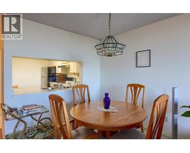 A dining room with a wooden table and chairs.