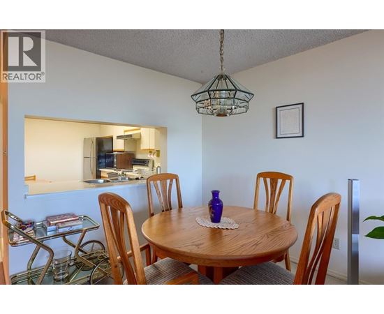 A dining room with a wooden table and chairs.