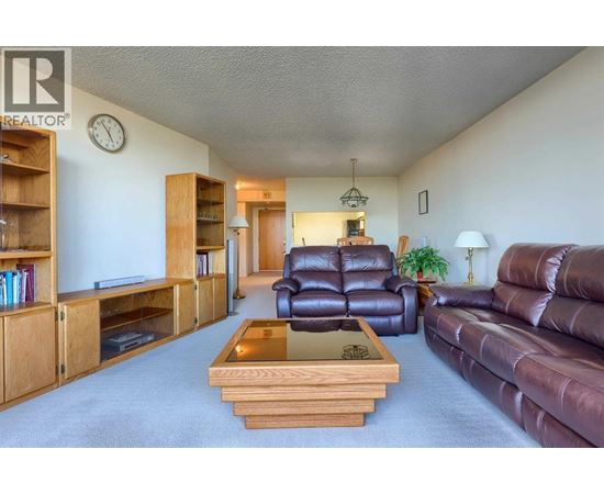 A living room with a brown leather couch and a wooden coffee table.
