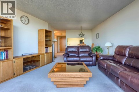 A living room with a brown leather couch and a wooden coffee table.