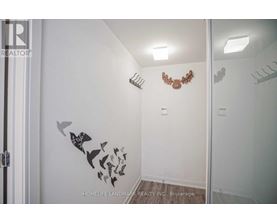 A white bathroom with a mirror and a wall decal of birds.