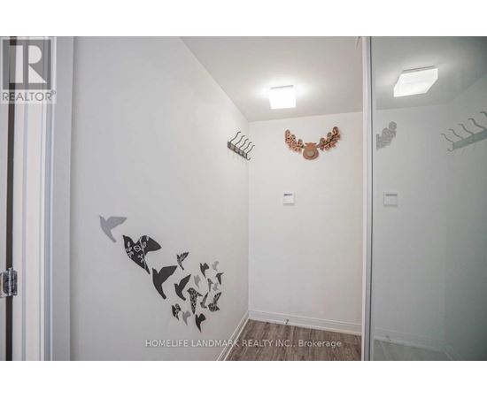 A white bathroom with a mirror and a wall decal of birds.