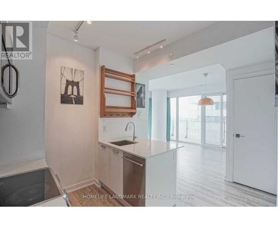 A kitchen with a sink and a fridge.