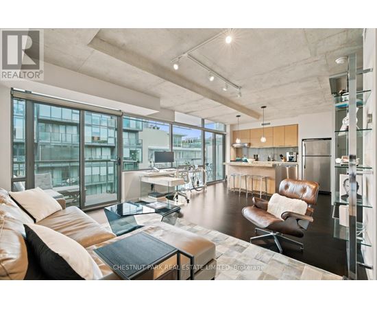 A modern living room with a brown leather couch and a glass table.