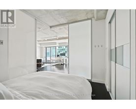 A bedroom with a large bed and a view of the city.