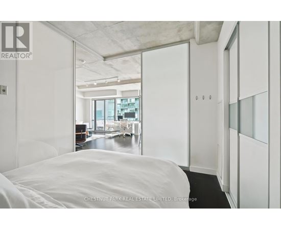 A bedroom with a large bed and a view of the city.