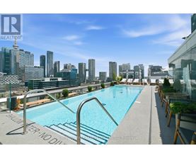A pool on a rooftop with a cityscape in the background.