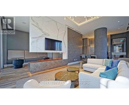A modern living room with a fireplace and a large couch.