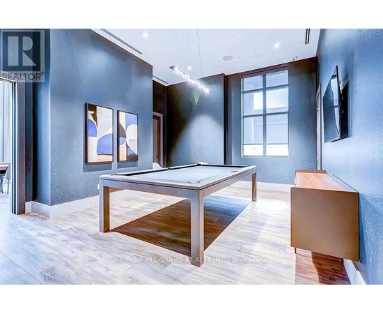 A room with a pool table and a tv mounted on the wall.