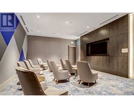 A conference room with chairs and a screen on the wall.