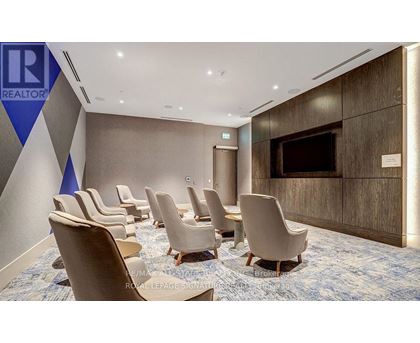 A conference room with chairs and a screen on the wall.