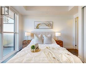 A bedroom with a large bed, a wooden headboard, and a framed picture on the wall.