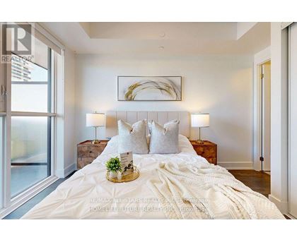 A bedroom with a large bed, a wooden headboard, and a framed picture on the wall.