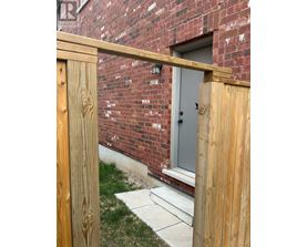 A wooden fence in front of a brick building.
