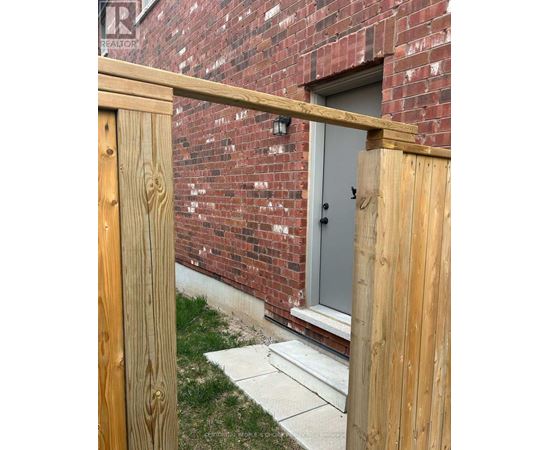 A wooden fence in front of a brick building.