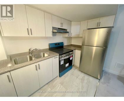 A kitchen with white cabinets and a stainless steel refrigerator.