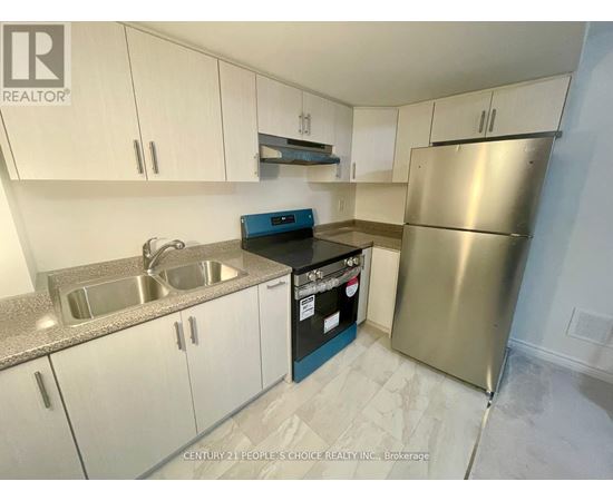 A kitchen with white cabinets and a stainless steel refrigerator.