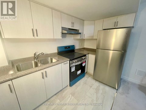 A kitchen with white cabinets and a stainless steel refrigerator.