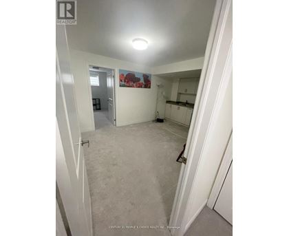 A bedroom with white walls and carpeting.