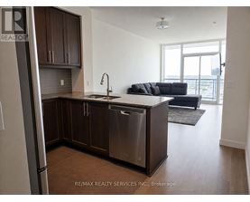 A kitchen with brown cabinets and a stainless steel refrigerator.