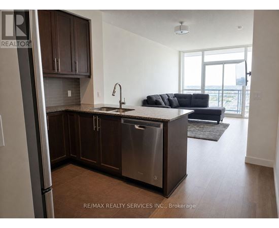 A kitchen with brown cabinets and a stainless steel refrigerator.