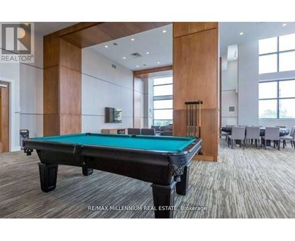 A pool table in a room with a brokerage logo.