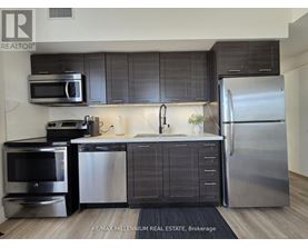 A modern kitchen with stainless steel appliances and dark wood cabinets.