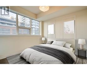 A bedroom with a large bed and a chandelier.