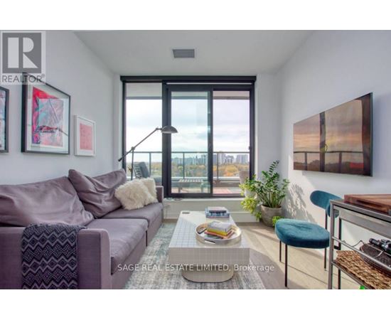 A living room with a purple couch and a coffee table with magazines on it.