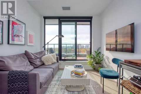 A living room with a purple couch and a coffee table with magazines on it.