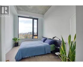 A bedroom with a large bed and a view of the city through the window.
