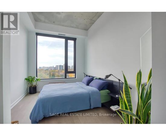 A bedroom with a large bed and a view of the city through the window.