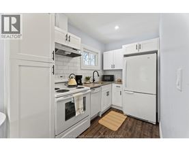 A white kitchen with a refrigerator, oven, and microwave.