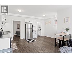 A kitchen with a refrigerator, a table, and a couch.