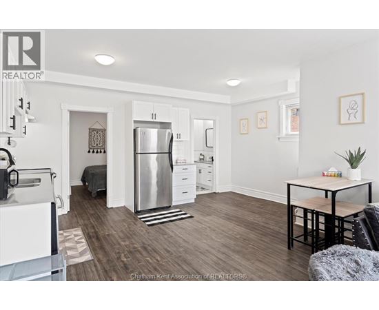 A kitchen with a refrigerator, a table, and a couch.