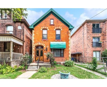 A red brick house with a green roof and a white door.