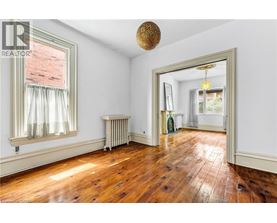 A room with wooden floors and a large mirror on the wall.