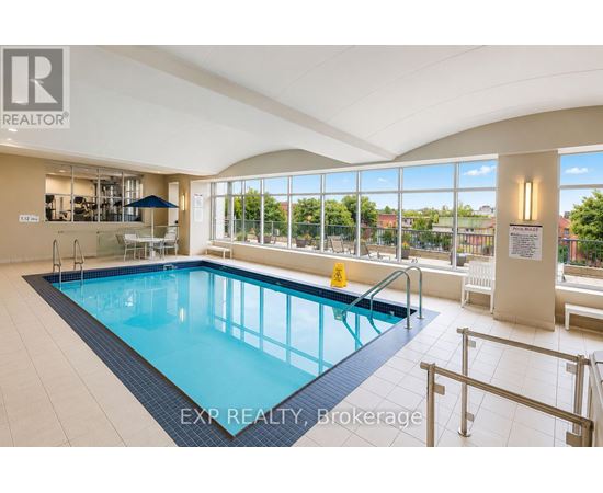 A large indoor swimming pool with a glass wall overlooking the outdoors.