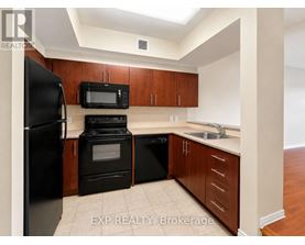 A kitchen with black appliances and wooden cabinets.