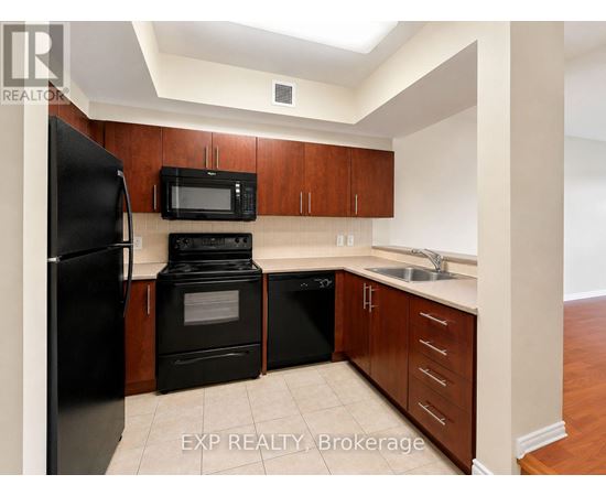 A kitchen with black appliances and wooden cabinets.