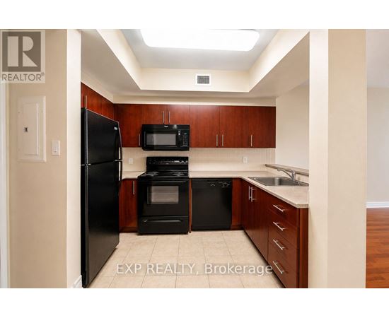 A kitchen with wooden cabinets and black appliances.