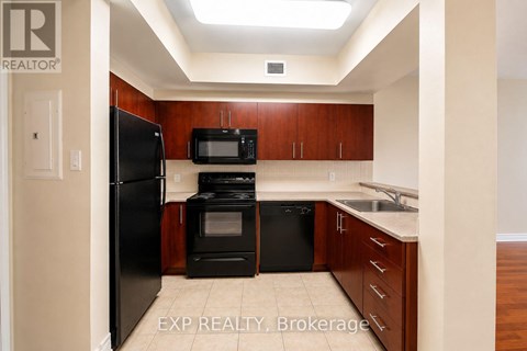 A kitchen with wooden cabinets and black appliances.