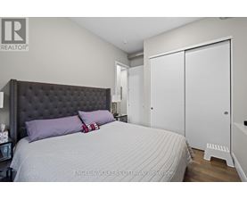 A bedroom with a large bed and a white wardrobe.