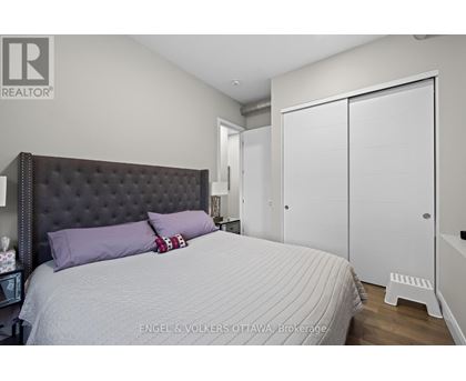 A bedroom with a large bed and a white wardrobe.