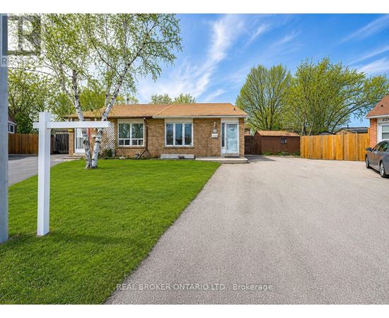 A residential house with a driveway and a white sign on the left.