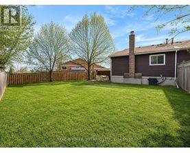 A backyard with a fence and a house in the background.