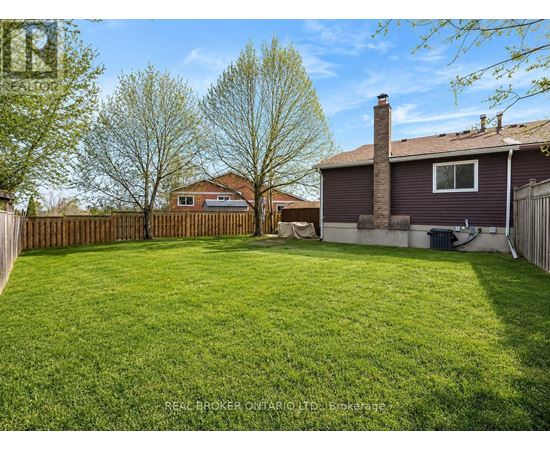 A backyard with a fence and a house in the background.