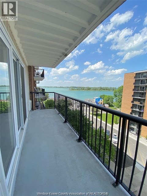 A balcony with a view of a body of water and buildings.