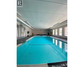 A large indoor swimming pool with a sign that says "Windsor-Essex County Association of REALTORS".